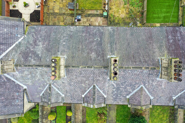 Aerial drone photo of a typical British terrace victorian house in the UK showing the roof of the house and the chimney in the winter time