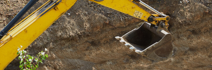 Excavator bucket in close-up view. Excavator bucket  against the backdrop of excavated soil.