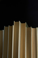 Books on a black background, vertical snapshot, books with white covers on a dark background