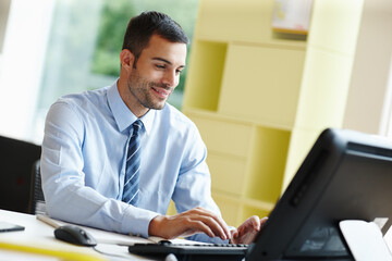 Fototapeta premium Happy, businessman and computer for positive feedback, good news or announcement in office. Excited, male person or employee with tech and paperwork waiting for communication and performance review