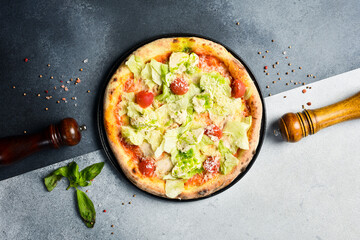 Traditional Caesar pizza. Pizza with lettuce, cherry tomatoes and sauce. Top view.