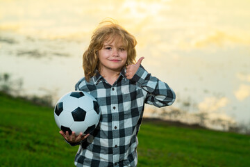 Child boy football or soccer player in action on soccer stadium kicking soccer ball for goal....