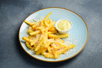 A plate of french fries with sauce. Close up. Fast food.