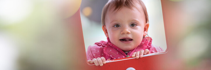 Cute baby girl having fun on a playground; panoramic banner