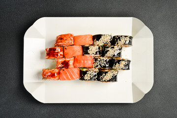 Sushi delivery box. Japanese salmon set menu in black transparent box. Top view.