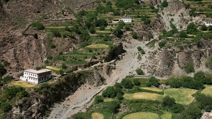 a tibetan village with terraces and houses on mountains
