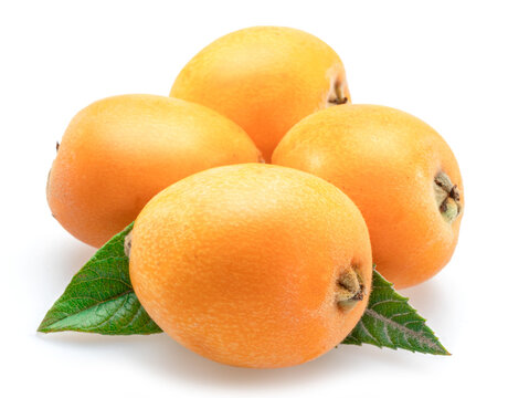 Ripe perfect loquat fruits with green leaves isolated on white background.