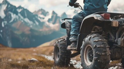 A person riding a four wheeler on a mountain. Suitable for outdoor activities promotion