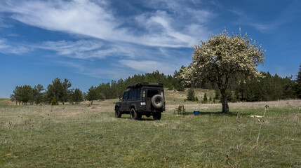 Off road vehicle and camping in the countryside. Meadows and picnic area outside the city in spring