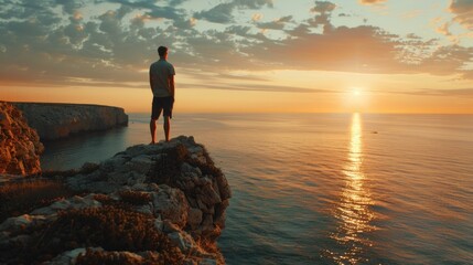 A man stands on a cliff with a view of the ocean. Perfect for travel and adventure concepts