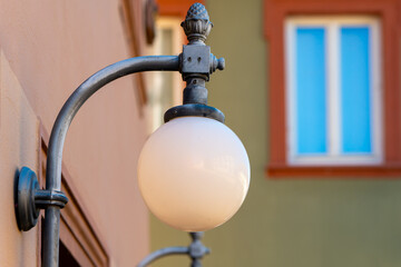 street light with a white globe is hanging from a metal pole
