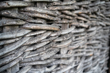 Background, texture of tree branches, spruce in the form of a protective fence. The fence is woven from dry branches, close-up. Wicker willow fence is a traditional wattle fence. © Nenad
