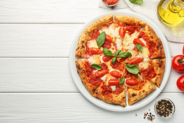 Delicious Margherita pizza and ingredients on white wooden table, top view. Space for text
