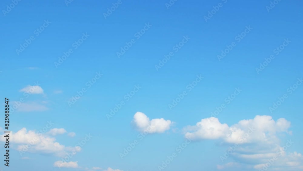 Wall mural white cumulus clouds slowly move in the blue summer sky. background with some clouds and empty space