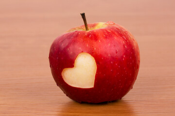 red apple with a heart on a wooden background