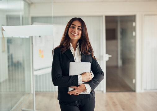Smiling businesswoman standing at the door of an office boardroom