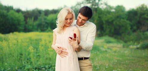 Fototapeta premium Wedding happy lovely young couple, man proposing a ring to his beloved woman outdoors in summer park