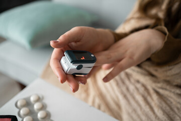 Close-up of hand with pulse oximeter on the finger. Prevention and treatment of flu home