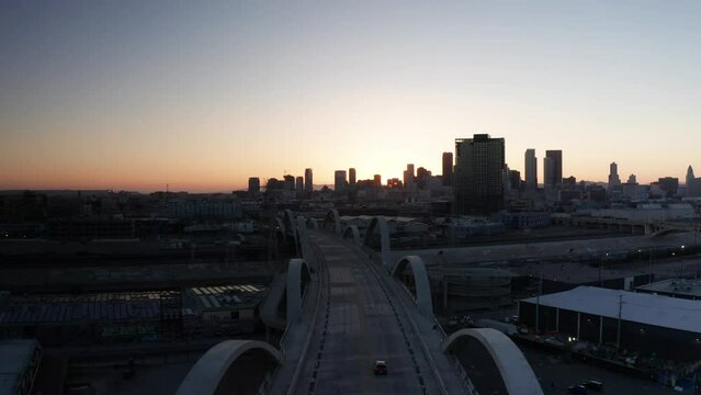 Wide rising aerial shot of the Sixth Street Bridge and Viaduct in downtown Los Angeles, California at sunset. 4K