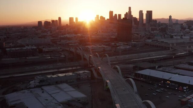 Descending aerial tilting up shot of the Sixth Street Bridge and Viaduct in Los Angeles, California at sunset. 4K