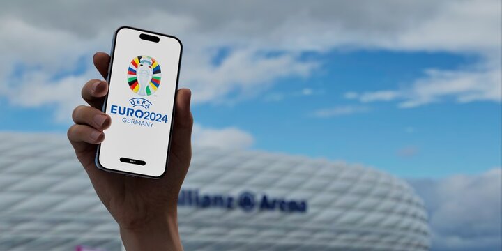 Euro 2024 app on a screen, against the backdrop of a Allianz Arena stadium - one of the venues of the event