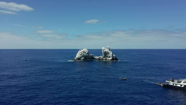 Dive boat near guano covered Roca Partida rocky islet in Pacific, aerial