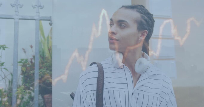 Young biracial man with headphones around neck looking thoughtful