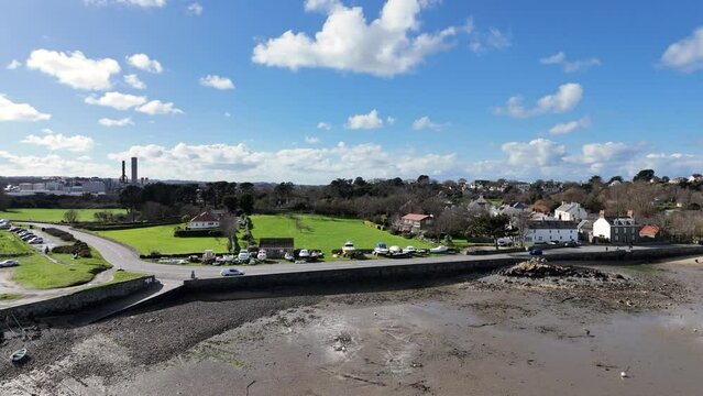 Bordeaux Harbour Guernsey circling drone shot on sunny day with boats on hardstanding and views over beach to St Sampsons