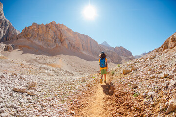 summer camp. boy with a backpack. child travels in the mountains with a backpack. summer hike in the high mountains.