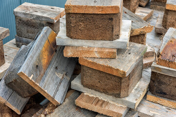 blocks of wood lie in a pile outside