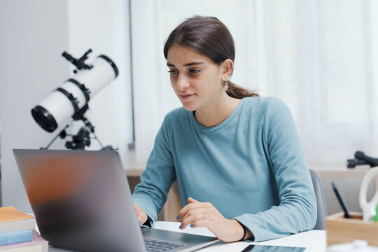Happy student connecting with a laptop