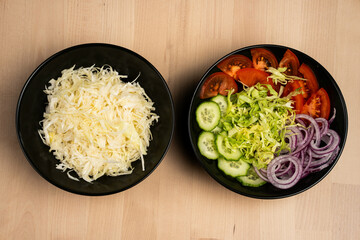 Top view of two plates of assorted fresh vegetables