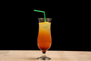 Refreshing orange beverage with a straw on a table against a dark backdrop