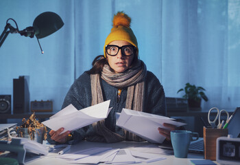 Woman feeling cold and checking bills