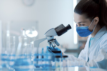 Scientist examining samples under a microscope