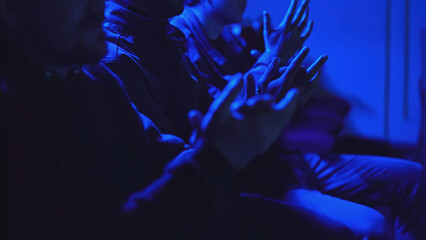 Close-up of audience applauding performance in dark hall. Media. Audience attentively watches and...