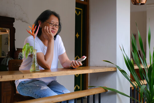 Woman sitting alone holding smartphone, waiting for someone