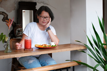 Woman sitting in her home veranda enjoying evening meal