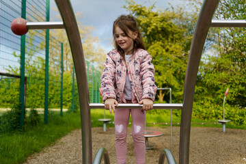 Obraz premium Small beautiful smiling girl on a sports ground in the summer
