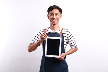 Young asian man barista barman employee wear blue apron work in coffee shop hold use tablet pc...