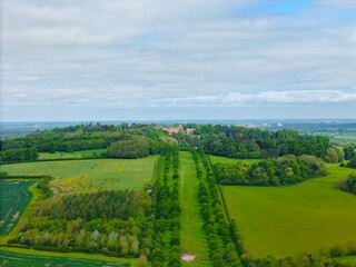 Aerial view of Waddesdon Manor atop a hill surrounded by lush green fields in Buckinghamshire.