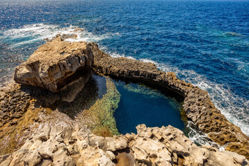 Blue Hole Viewpoint Dwejra Bay, rock formation on the Mediterranean sea. Natural arch window in rock. Gozo island Malta.
