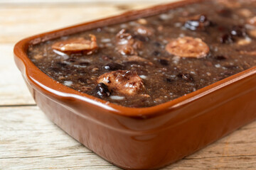 Delicious Brazilian Feijoada, a traditional stew made with black beans, pork, and beef in a ceramic dish.