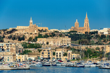 Mgarr bustling waterfront on the Gozitan isle, a scenic maritime hub showcasing Malta irresistible appeal as a Mediterranean paradise. Malta travel destination.