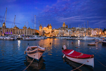 Senglea city, part of the Three Cities of Malta. Night marina glows under the night sky, yacht...