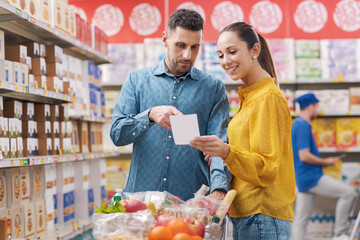 Happy couple doing grocery shopping at the supermarket