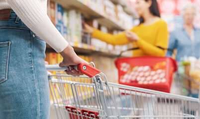 Woman doing grocery shopping at the supermarket close up