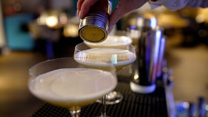 Adding seasoning to a cocktail, close-up. The bartender adds seasonings to the cocktail.