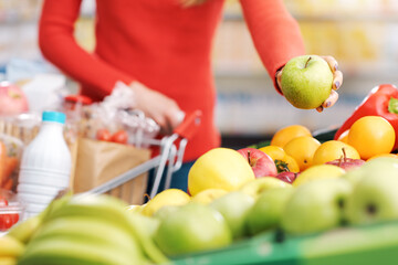 Woman buying fresh fruit at the grocery store