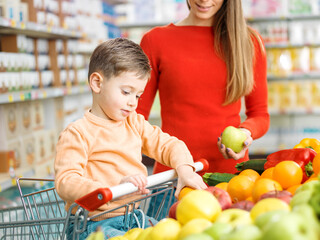 Young mother and kid buying fresh fruits